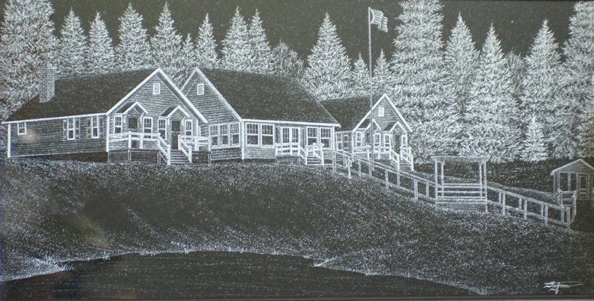Hand etching on black granite of a lakeside house with a flagpole, pine woods behind and water in the foreground